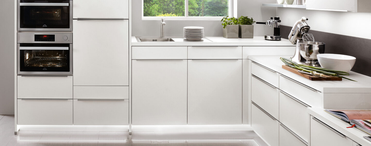 Bild einer weißen Küche mit unterschiedlichen Arbeitshöhen
