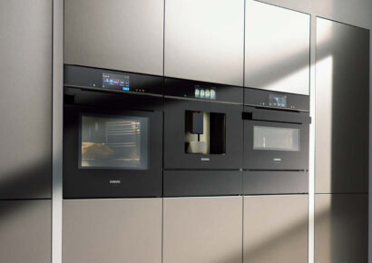 Drei Kombigeräte in der Küche von Siemens in einer grauen Küchenwand.