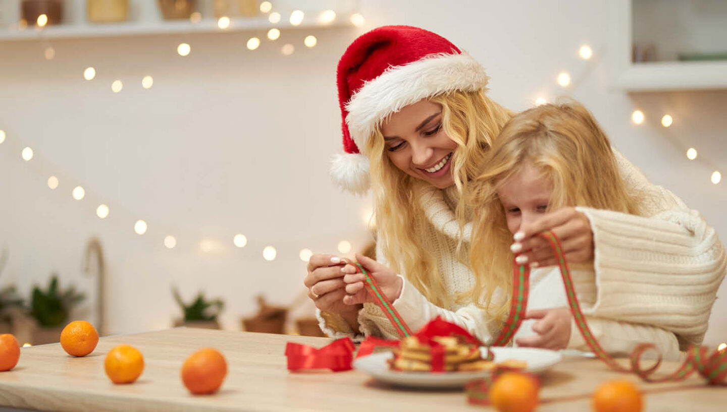 Eine Frau und ein Mädchen verpacken gemeinsam Plätzchen.