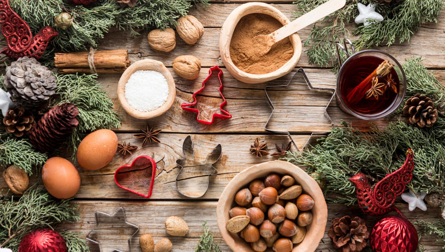 Arrangement von Backzutaten, Nüssen und Plätzchenausstechern.
