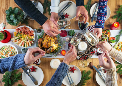 Viele Hände über einem Festlichen Weihnachtsessen.