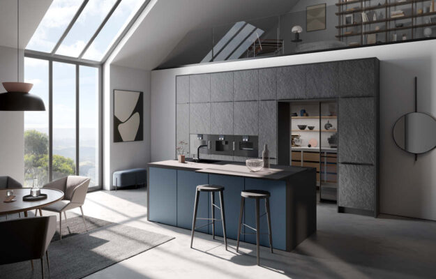 Graue Küche mit blauer Kochinsel und schwarzer Arbeitsplatte, sowie Hauswirtschaftsraum hinter den Hochschränken.