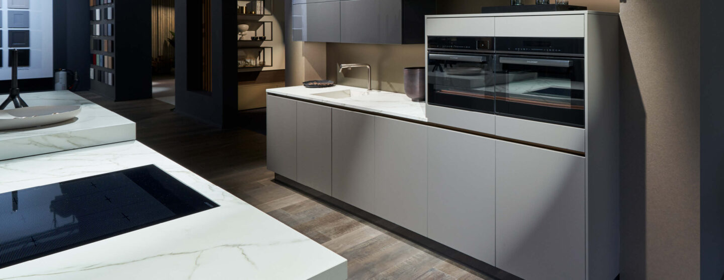 Grifflose Einbauküche mit integriertem Backofenhochschrank und großzügiger Arbeitsfläche in modernem Küchendesign.