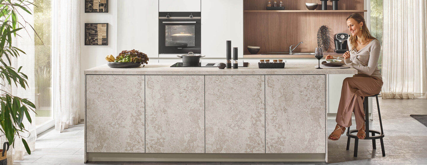 Frau genießt Mittagessen an einer Kochinsel. Atmosphäre in der Küche