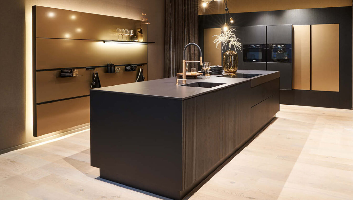 Dunkle Küche mit goldenen Akzenten und atmosphrisch-warmem Licht.