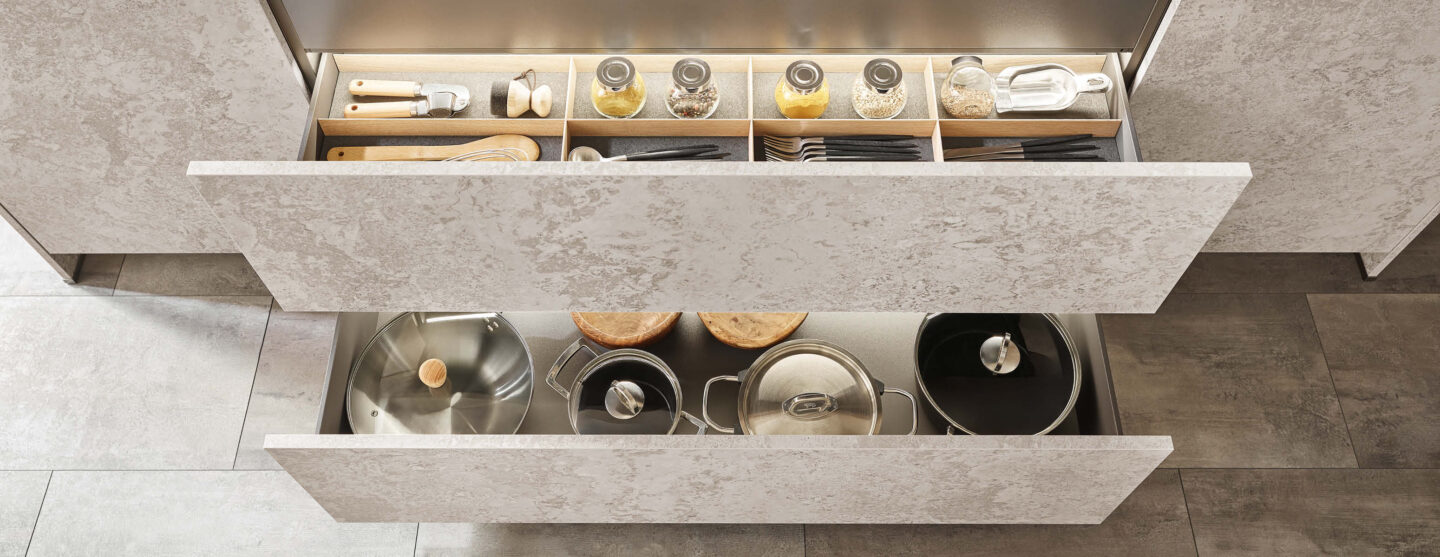 Durchdachter Stauraum, geöffnete Auszüge mit Ordnungssystemen für Besteck, Gewürze und Kochutensilien.