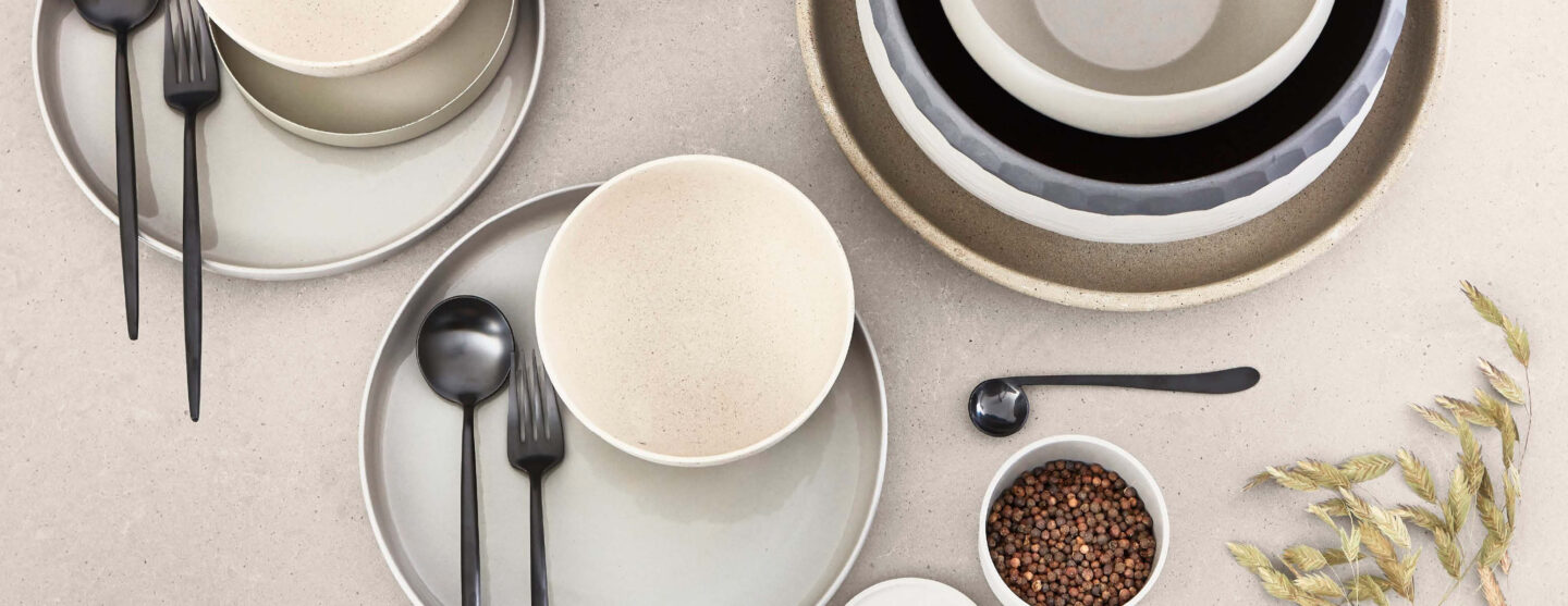 Weiße und graue Schüsseln auf einer weißen Arbeitsplatte arrangiert.