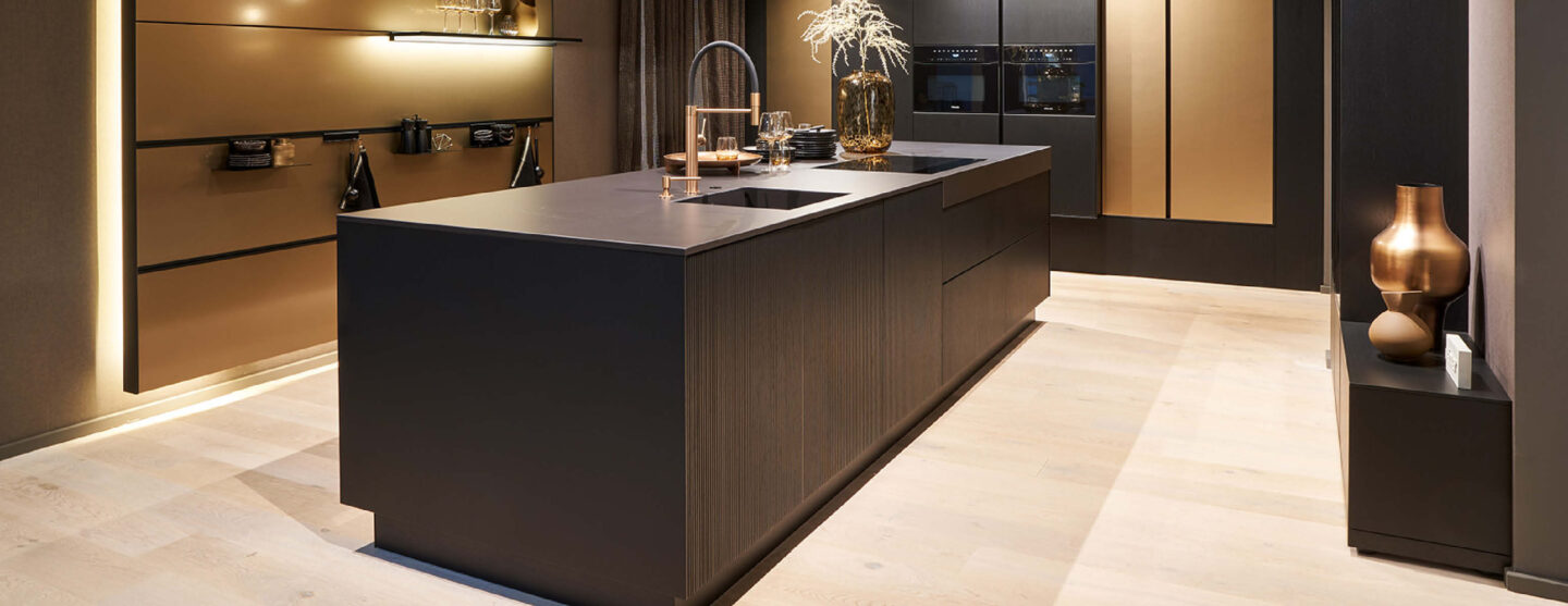 Moderne, schwarze Küche mit goldenen Akzenten und stimmungsvollem Licht – Atmosphäre in der Küche