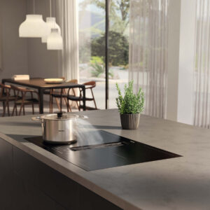 Miele Induktionskochfeld mit integriertem Dunstabzug auf Kücheninsel.