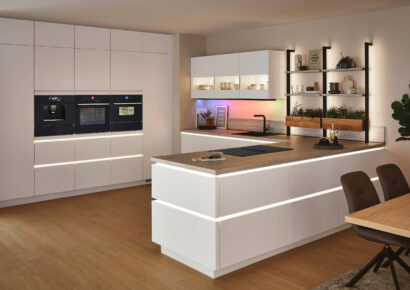 Moderne Nobilia Küche in Weiß mit Kücheninsel, Holzarbeitsplatte und integrierten Einbaugeräten – stilvolle Küchenplanung bei Küchenstyle.