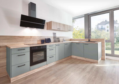 Klassische Nobilia Küche in Salbeigrün mit Holzarbeitsplatte, L-Form und schwarzen Griffen – zeitloses Küchendesign bei Küchenstyle.