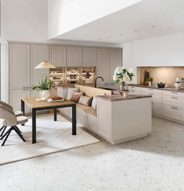 Große Nobilia Landhausküche in Beige mit Kochinsel, Sitzbank und Essbereich.