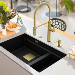Franke Küchenspüle mit schwarzem Becken und goldfarbener Armatur, integriert in moderne Kücheninsel mit Lebensmitteln und Geschirr