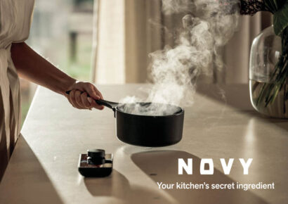 Frau hält dampfenden Kochtopf über Kochfeld von novy undercover dazu Logo von novy