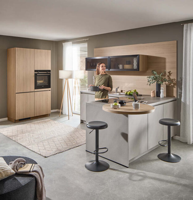 Moderne Häcker Küche mit Kücheninsel, Holzoptik und hellen Fronten – stilvolle Einbauküche im Küchenstudio Küchenstyle.