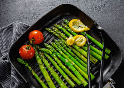 Grüner Spargel mit Zitronen und Tomaten in Grillpfanne