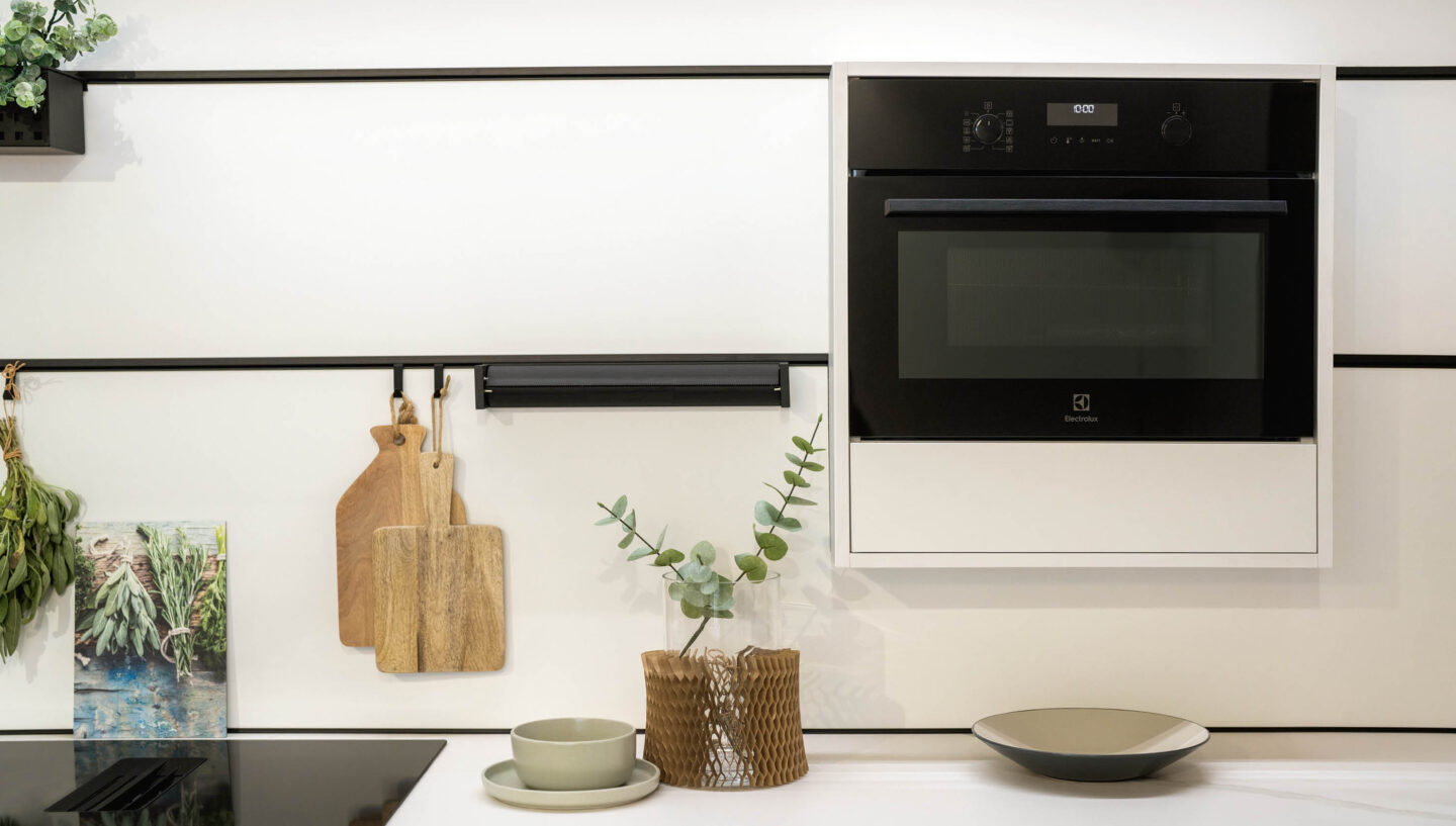Wandpaneele in heller Küche von Rotpunkt mit Backofen und Küchenaccessoires