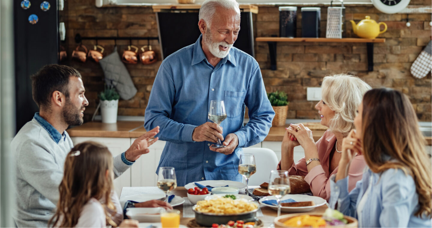 Mehrere Generationen einer Familie genießen eine gemeinsame Mahlzeit am gedeckten Tisch